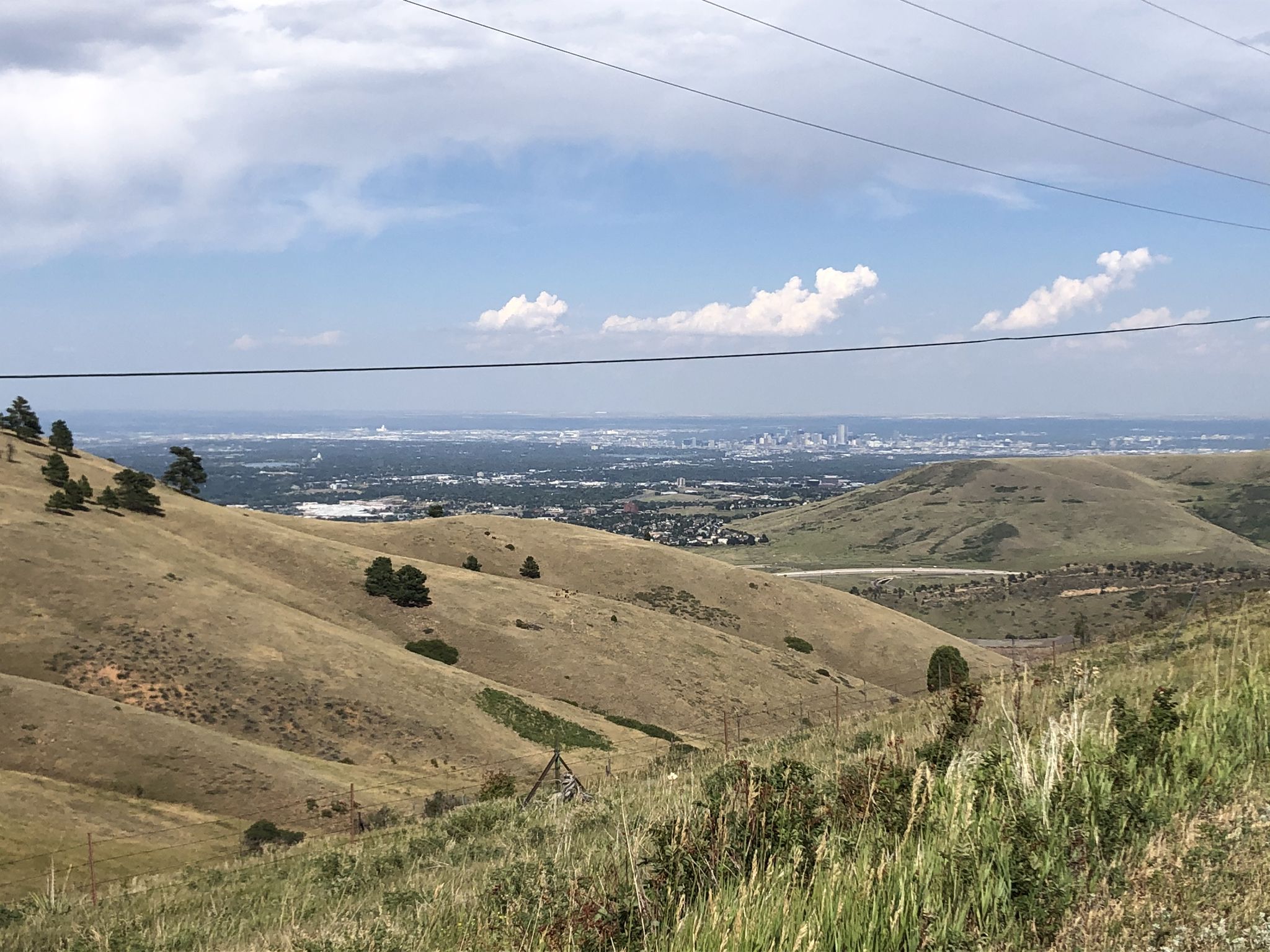Rolling dry hills overlook a distant city under a partly cloudy sky. - Mother Cabrini Shrine Climb