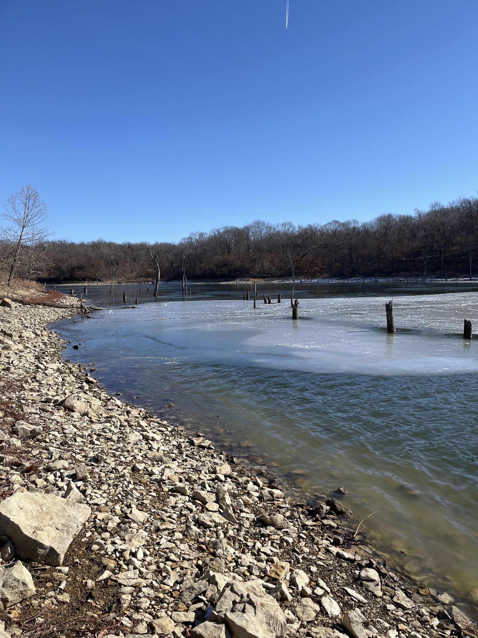 Partially frozen lake with a rocky shore and bare trees under a clear sky. - Copperhead Ridge Trail loop from Smoke and Davey Trailhead Parking