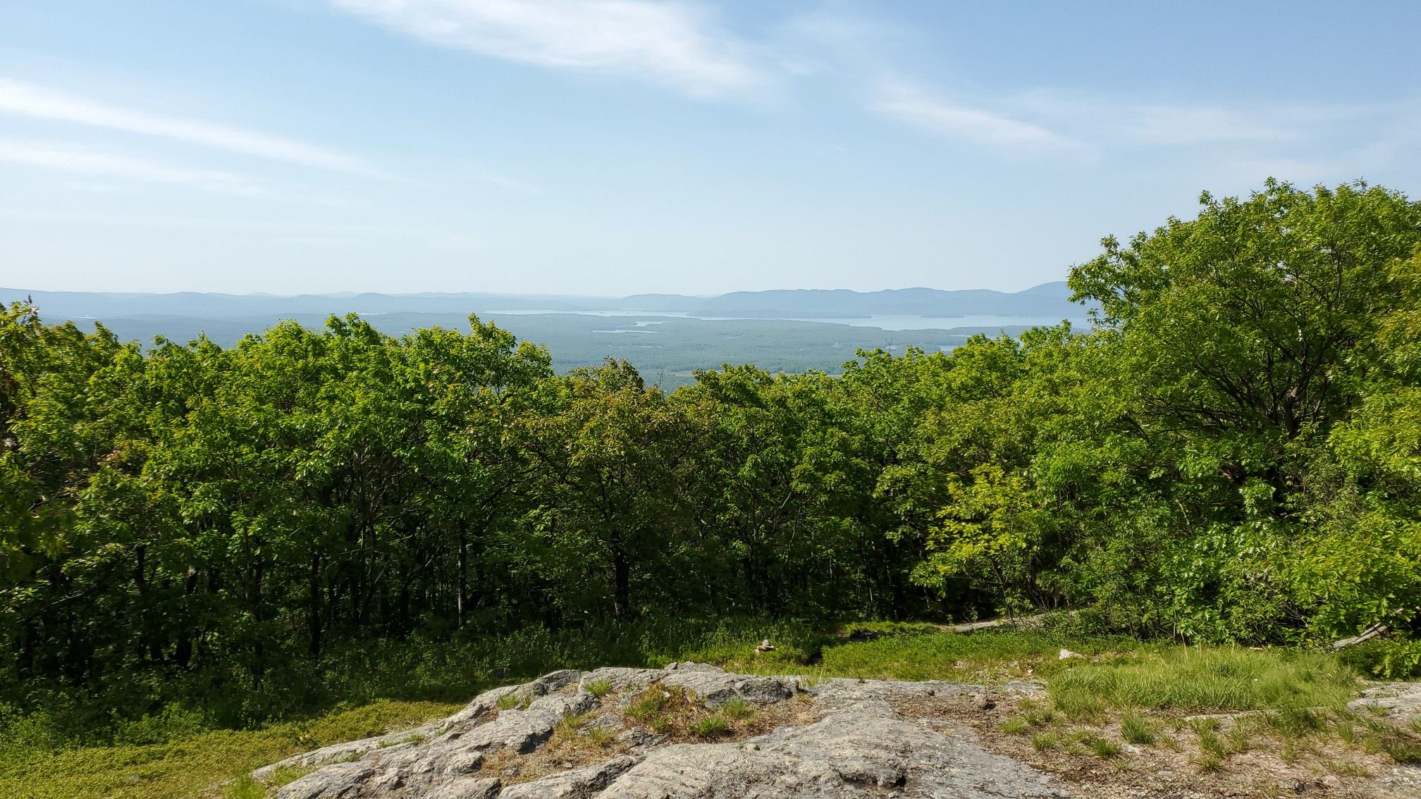 Sunny view over green treetops to distant water and hills. - Big Ball Mountain via Italian Trail