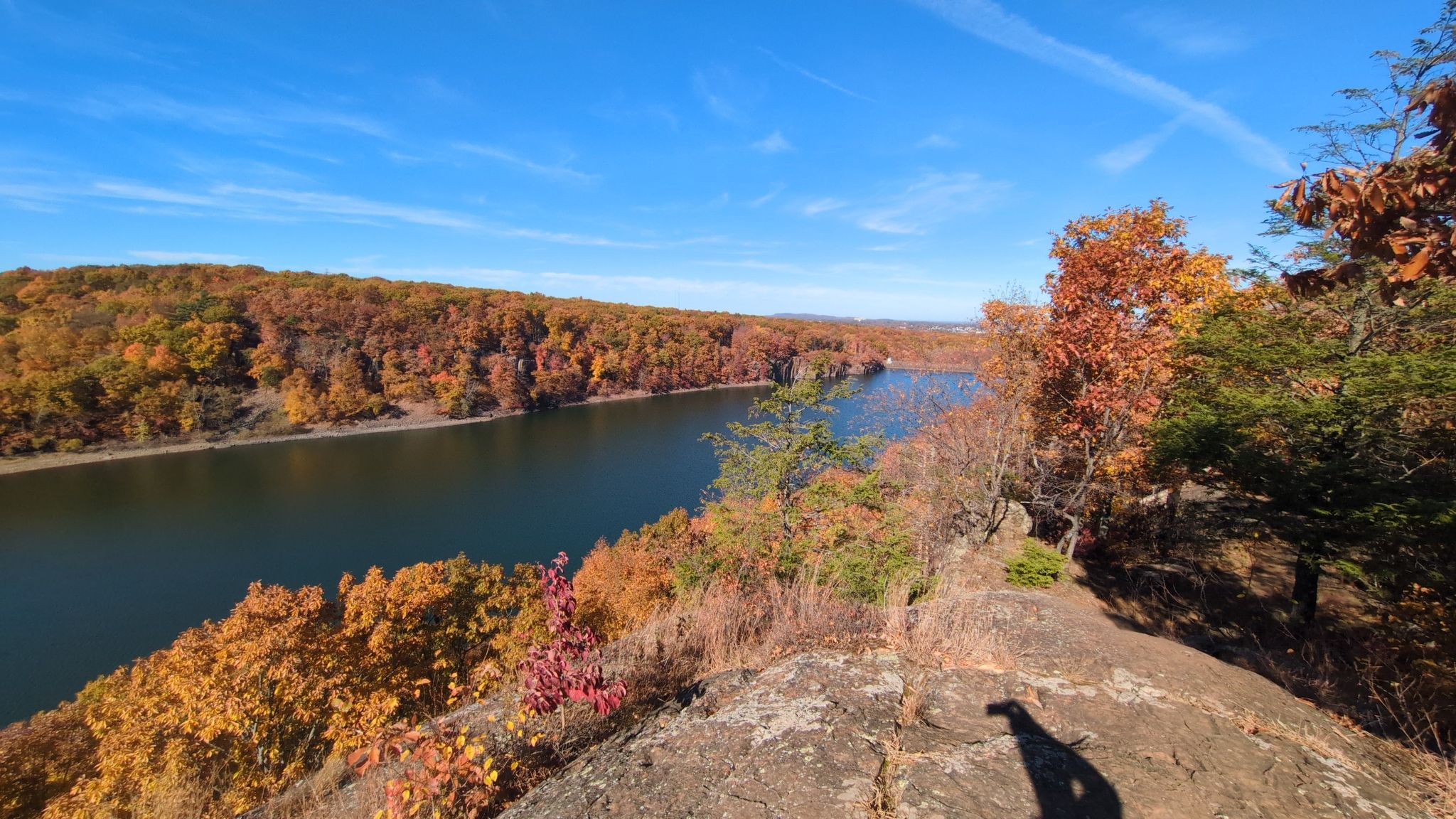 Sunny autumn view of a winding river surrounded by colorful trees. - Metacomet Trail Loop