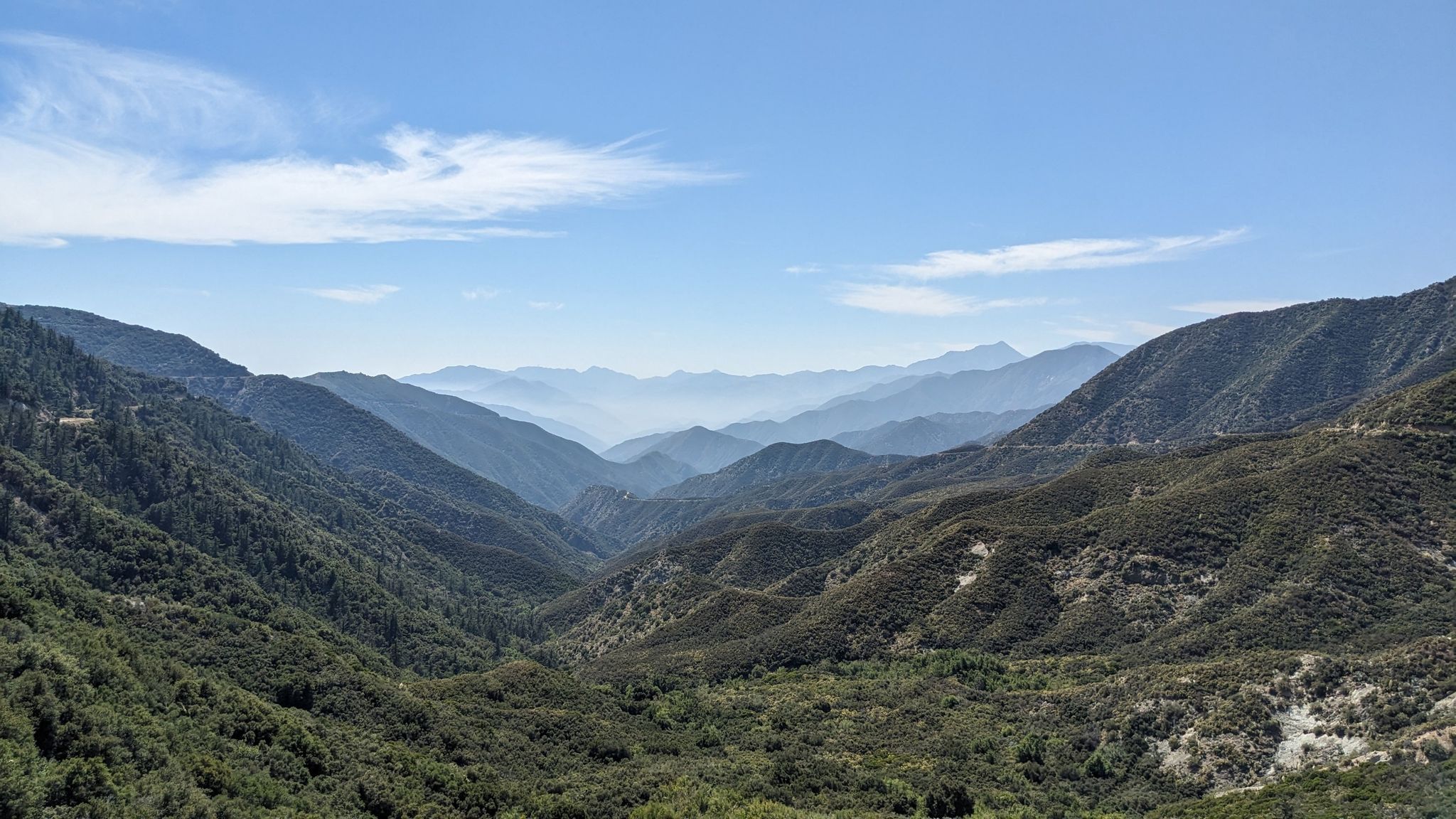 Expansive view of layered green mountains and a deep valley under blue sky. - Rubel Castle – Little Dalton Debris Basin loop from Montclair