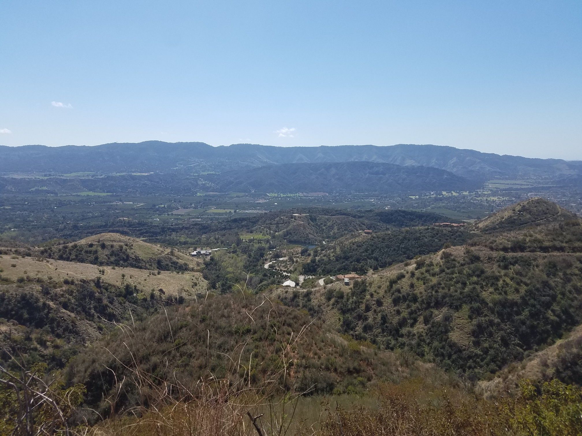 Wide panoramic view of a vast valley and distant mountains under clear sky. - Gridley and Pratt Trail Loop
