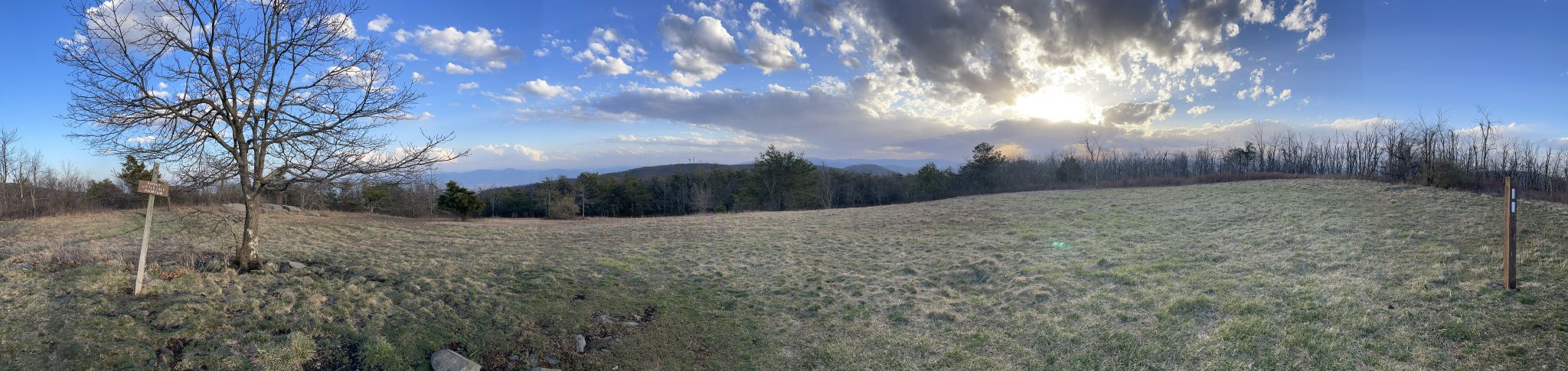 Panoramic view of a grassy field, bare trees, and distant mountains under a cloudy sky. - Appalachian Trail: Beagle Gap to Sawmill Run Overlook