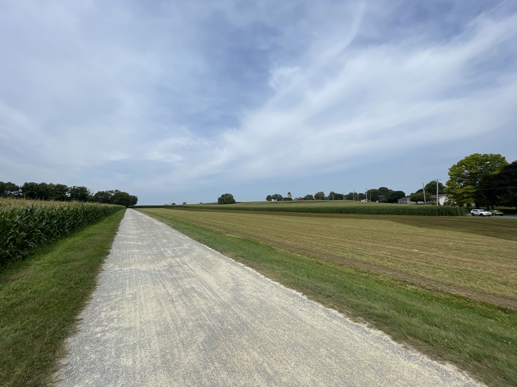 A wide gravel path stretches through open fields under a cloudy sky. - Lititz – Gravel section loop from Ephrata