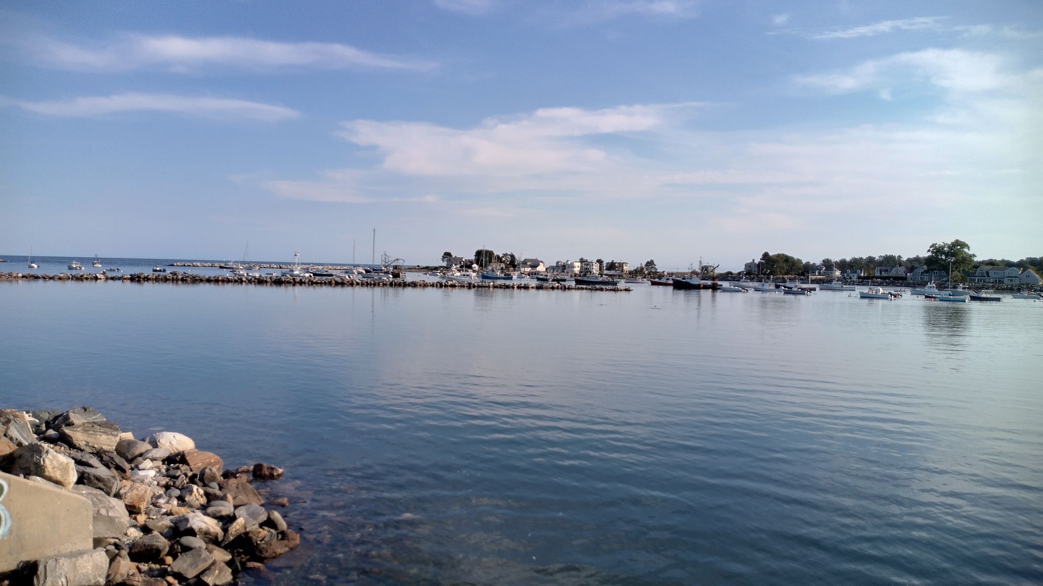 A calm harbor filled with many boats under a bright blue sky. - East Coast Greenway: New Hampshire Seacoast