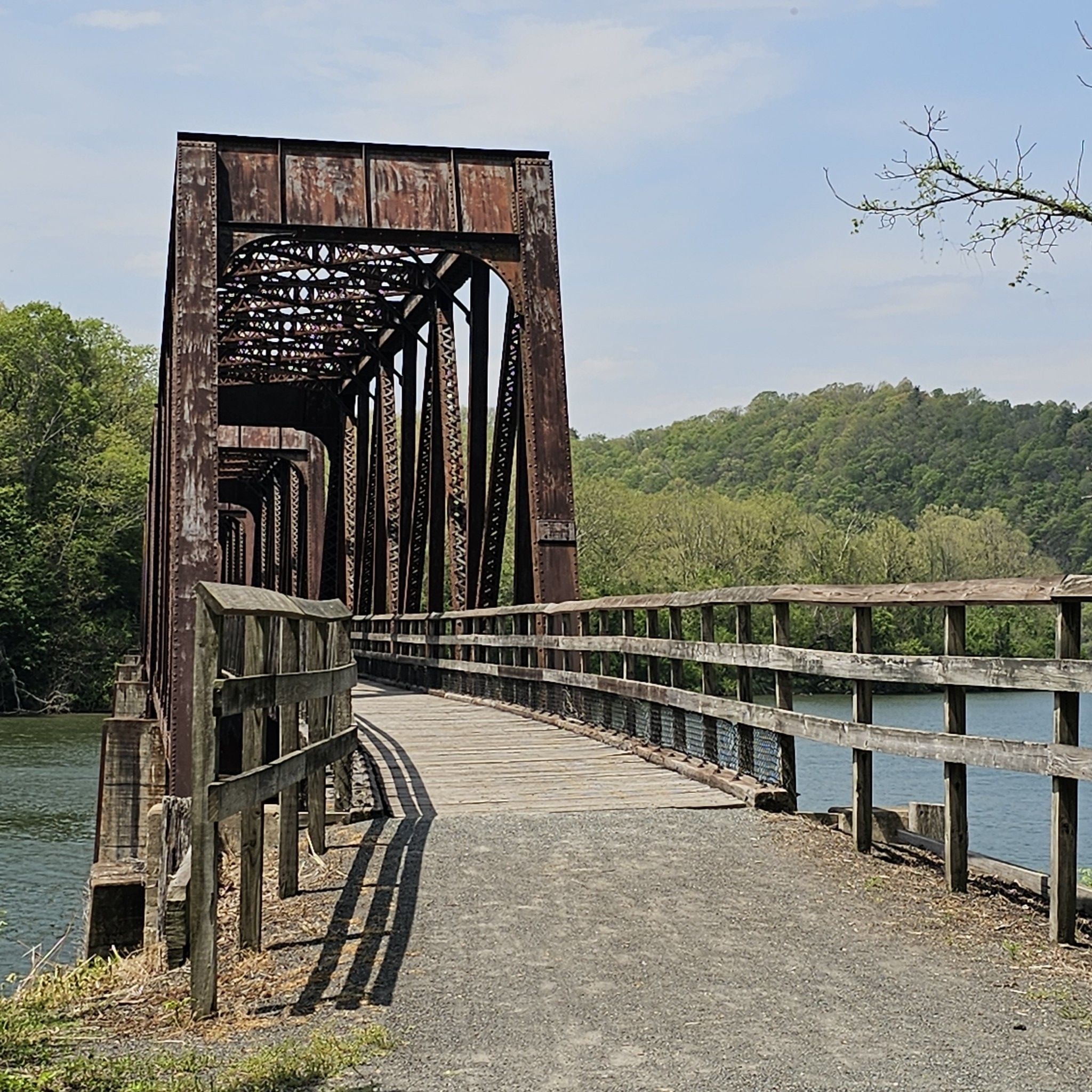 Large metal bridge with wooden railings over a river on a sunny day. - New River Bridge – Whistle Stop Inn loop from Radford
