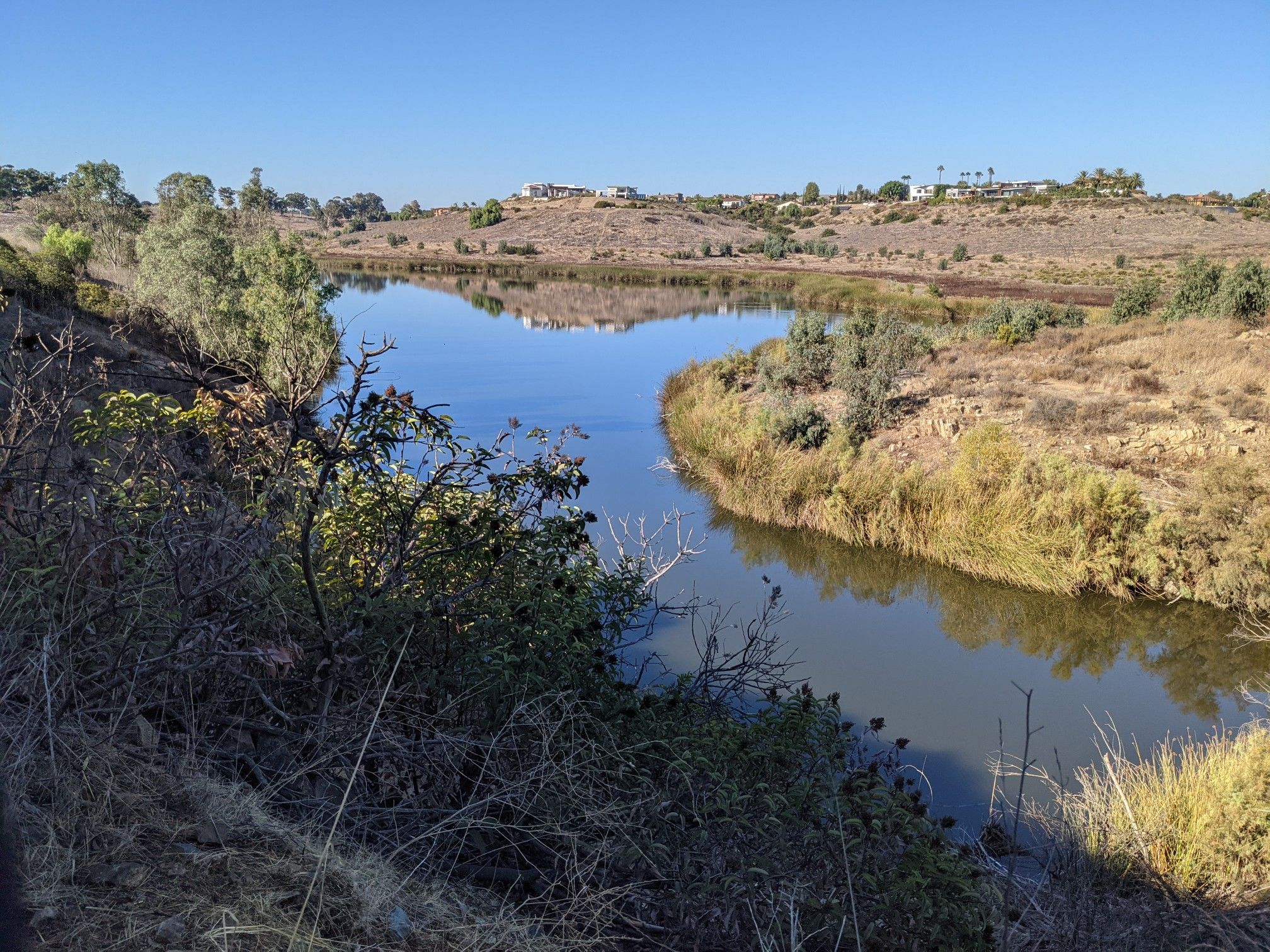 Winding river through dry hills under a clear blue sky. - Upper Otay Reservoir – Lower Otay Reservoir loop from Lower Otay Reservoir