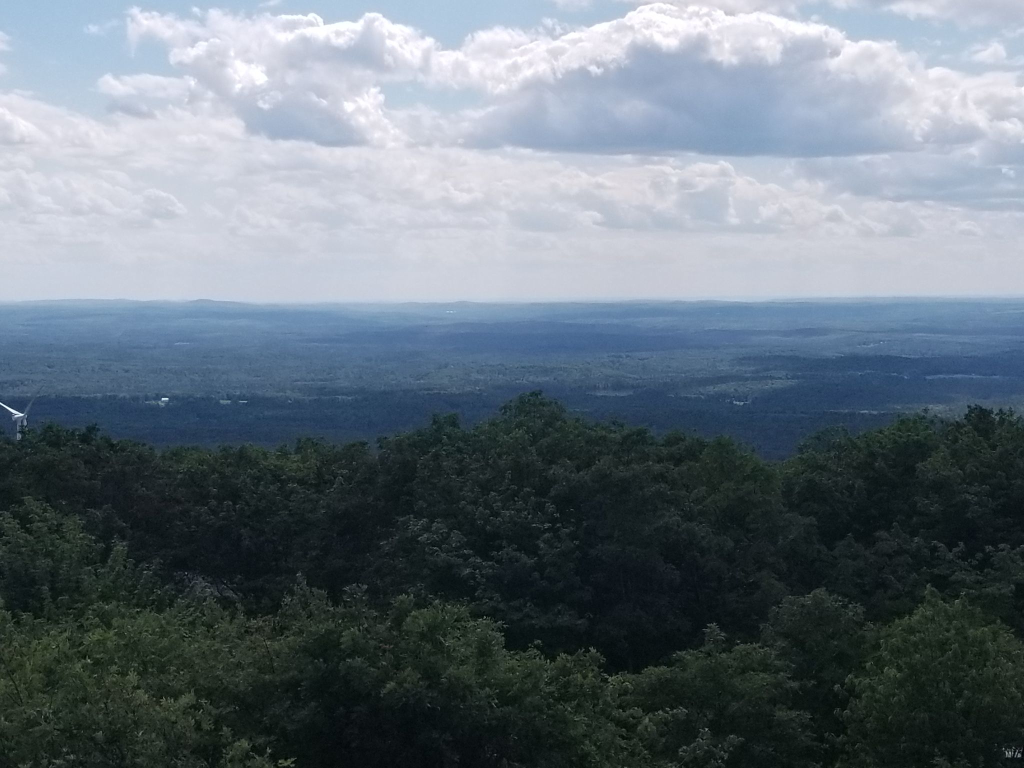 An expansive view of rolling green forests under a partly cloudy sky. - Wachusett Mountain Old Indian, Stage Coach, Bicentennial Trails