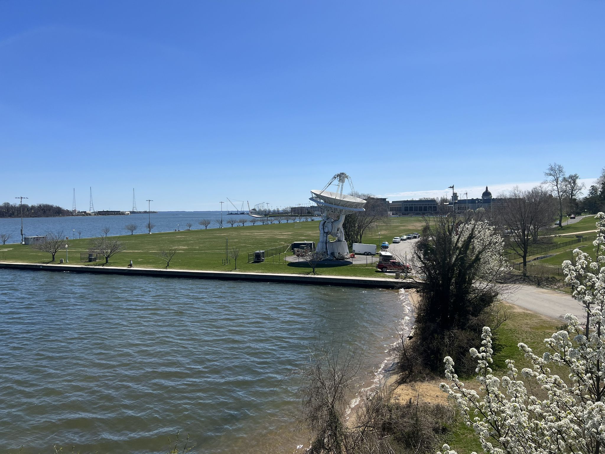 Modern sculpture on a grassy bank next to water under a clear blue sky. - Severn River views – Baltimore & Annapolis Trail loop from Annapolis