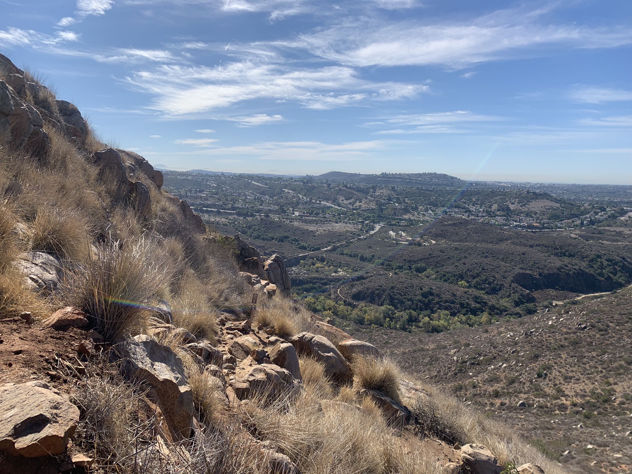 Steep, rocky hillside with dry grass overlooking a vast valley under a blue sky. - South Fortuna and North Fortuna Loop