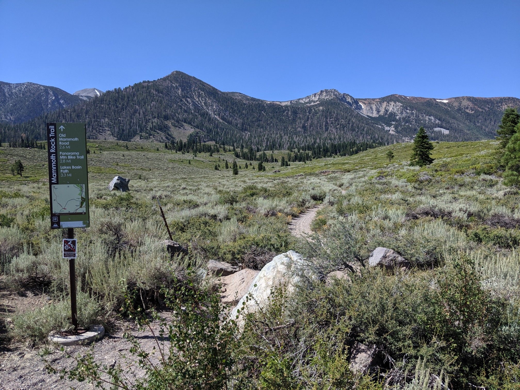 A trail sign stands beside a dirt path leading into a mountain landscape. - Mammoth Rock Trail – Mammoth Rock Trail loop from Mammoth Lakes