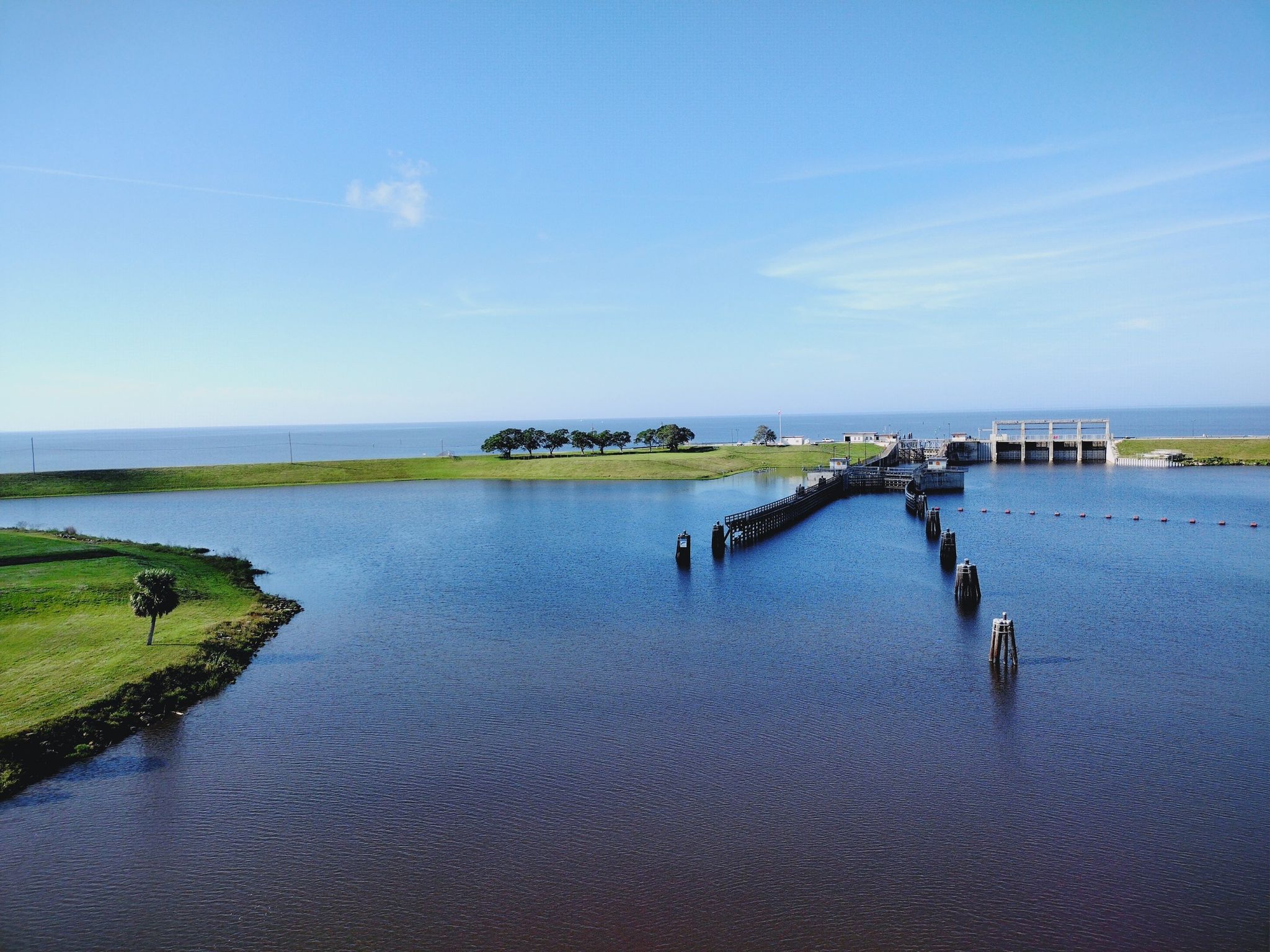 Aerial view of a large lake with a distant dam under a clear sky. - Port Saint Lucie to Lake Okeechobee century loop