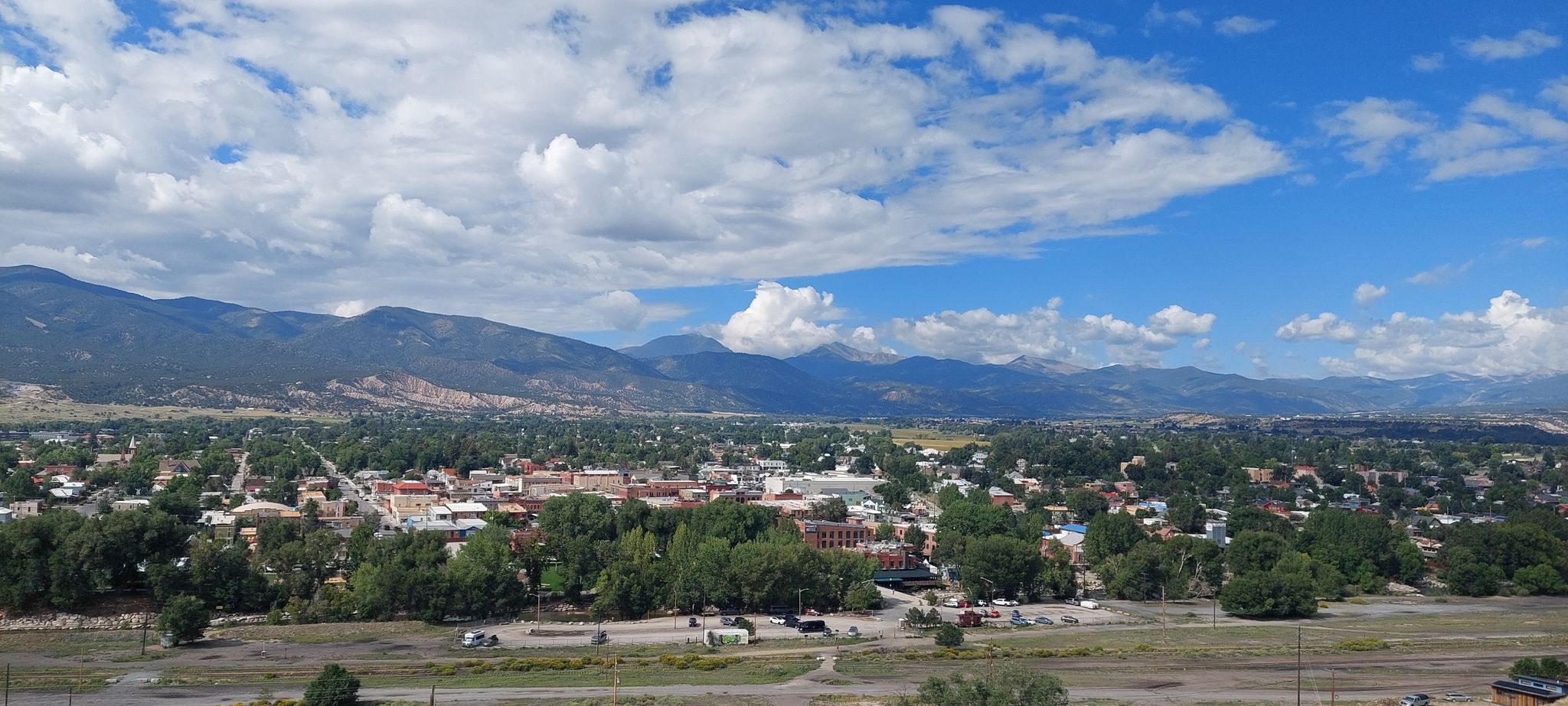 An aerial view of a town nestled in a valley with mountains under a partly cloudy sky. - Frontside and Tenderfoot Loop