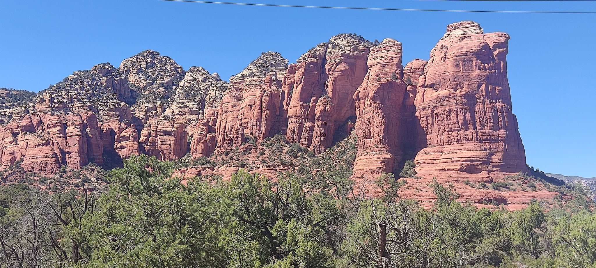 Towering red rock formations under a clear blue sky, with green trees below. - Crusty, Grand Central, Teacup, & Adobe Jack Trail loop — Coconino National Forest