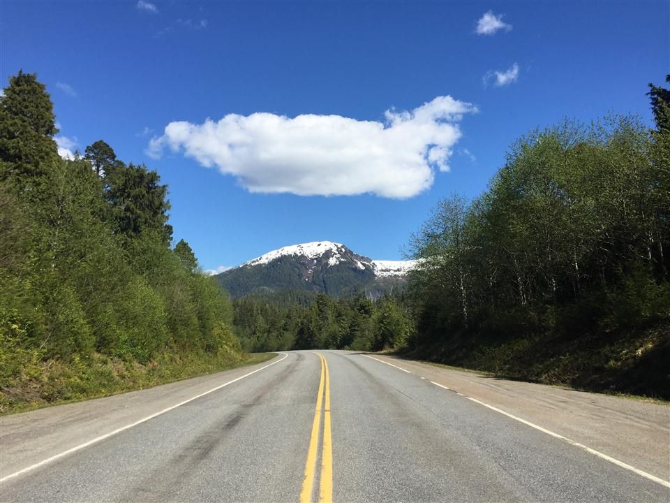 A straight road leads towards a snow-capped mountain under a bright blue sky. - Pipeline and Ward Creek Loop