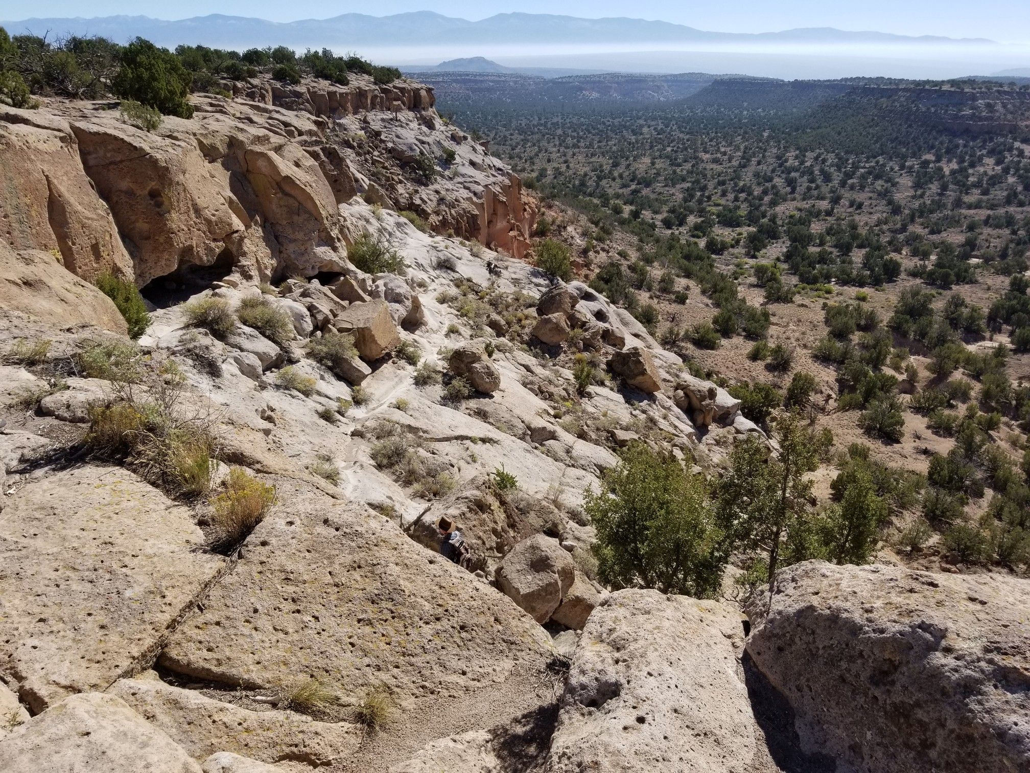 Rocky desert landscape with sparse vegetation under bright daylight. - Tsankawi Loop Trail