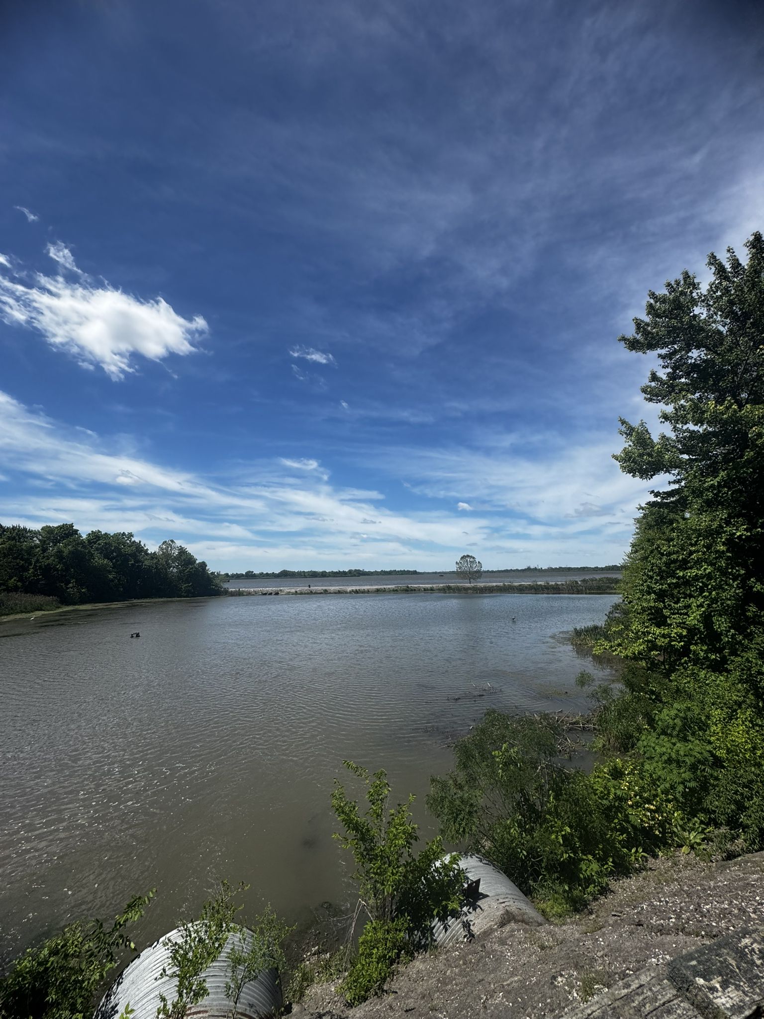 Wide body of water under a bright blue sky with scattered clouds. - Roadbike loop from Troy