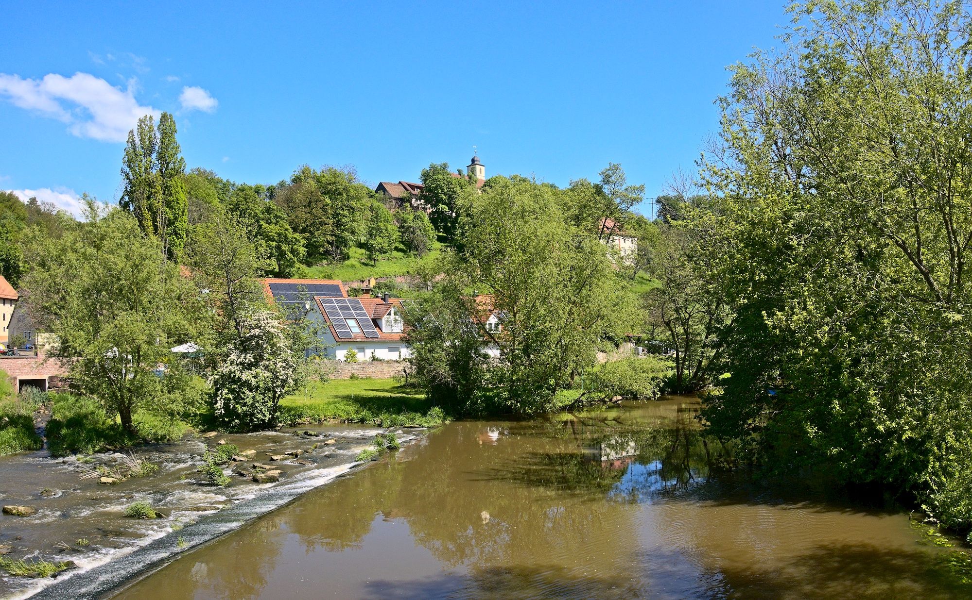 An der Fränkischen Saale in Aura an der Saale. Oben spitzt unser nächster Wegpunkt hervor, ...
