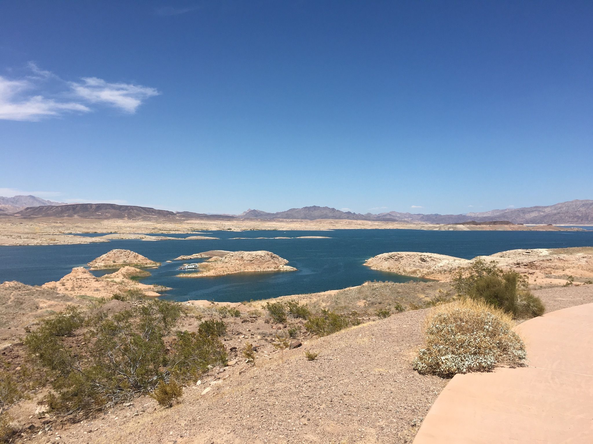Wide view of a blue lake with rocky islands and arid landscape. - Sunset View Scenic Overlook Trail