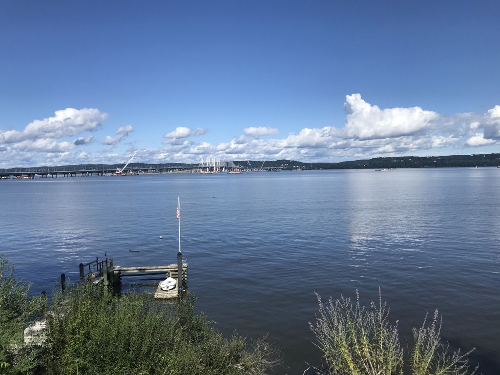 Expansive water body with a distant bridge and a small dock on a sunny day. - Rockland Lake West Side Path – Piermont Railway Station (historic) loop from Valley Cottage