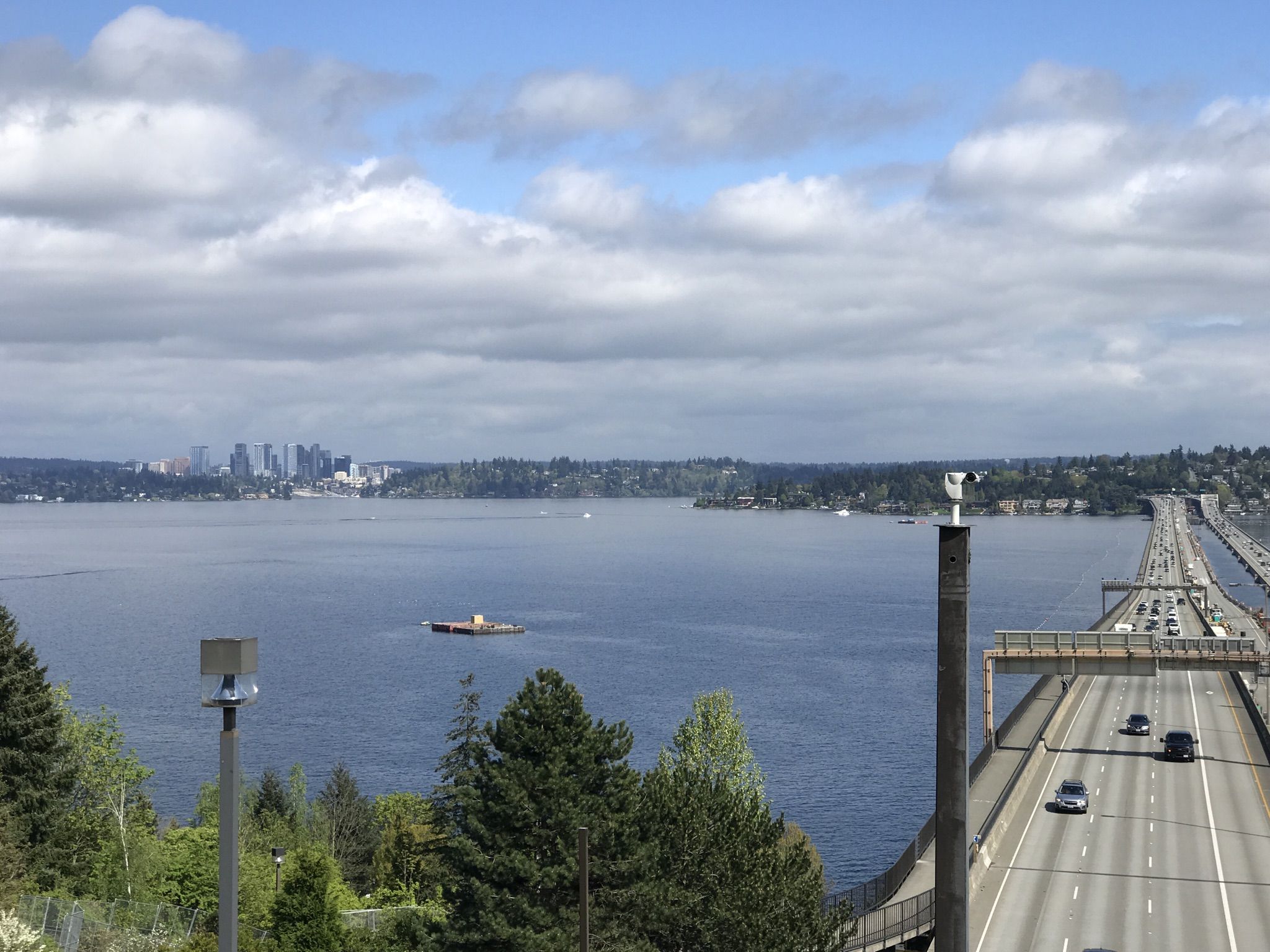 Elevated view of a busy highway bridge over water, with a distant city. - Mercer Island/Madrona loop