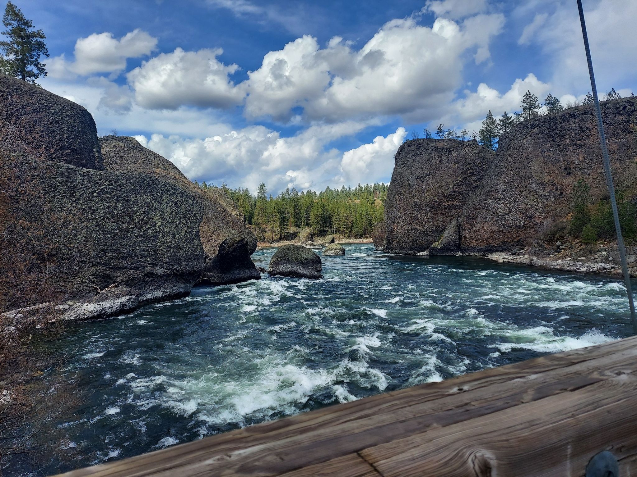 Rushing river between large rock formations under a partly cloudy sky. - Trail 25 and Centennial Loop