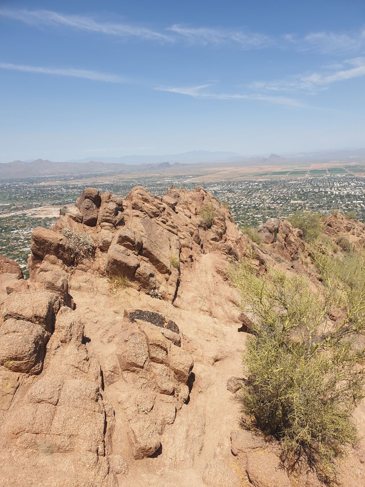 Rocky mountain peak overlooking a sprawling city under a clear sky. - Hiking loop from Scottsdale