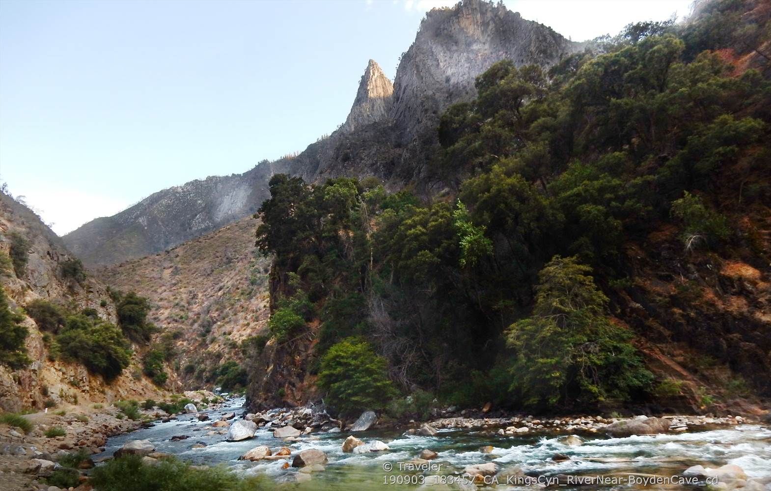A river flows through a rocky canyon with steep, forested slopes under a bright sky. - Hume Lake to Kings Canyon National Park via Kings Canyon Scenic Byway
