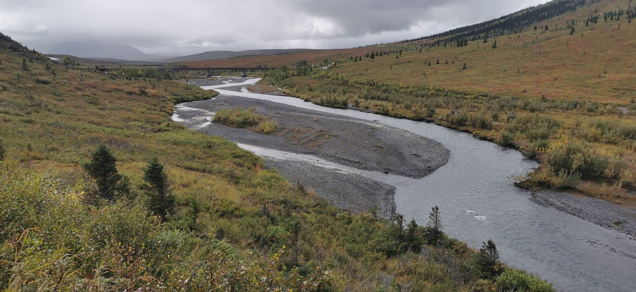 River winding through a wide valley with green and brown hills under cloudy sky. - Savage River Loop Trail