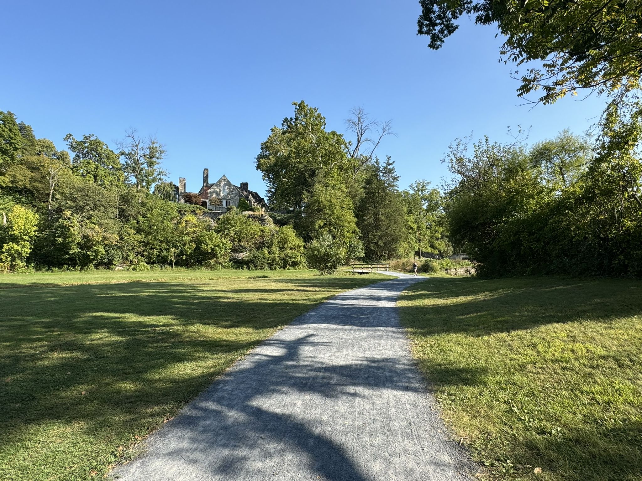 Gravel path through a sunny green field, with a large house on a hill. - Wertz's Covered Bridge loop from Berkshire Mall