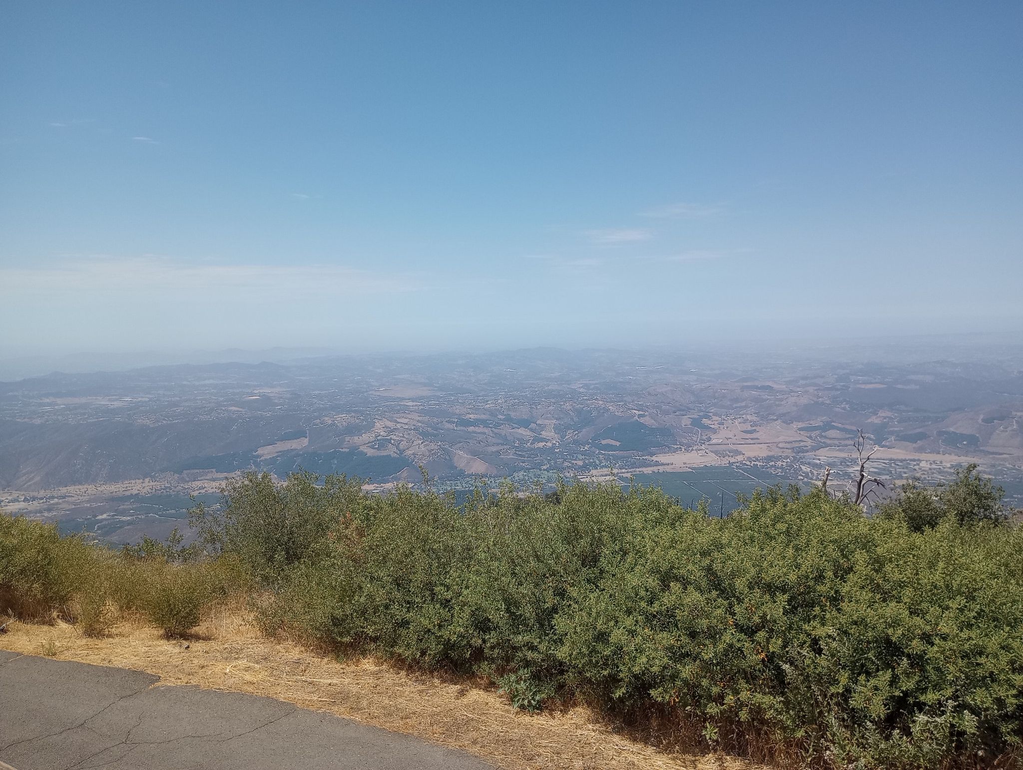 Panoramic view of a vast, hazy valley from a high vantage point. - Palomar Mountain – Boucher Hill loop from Funner