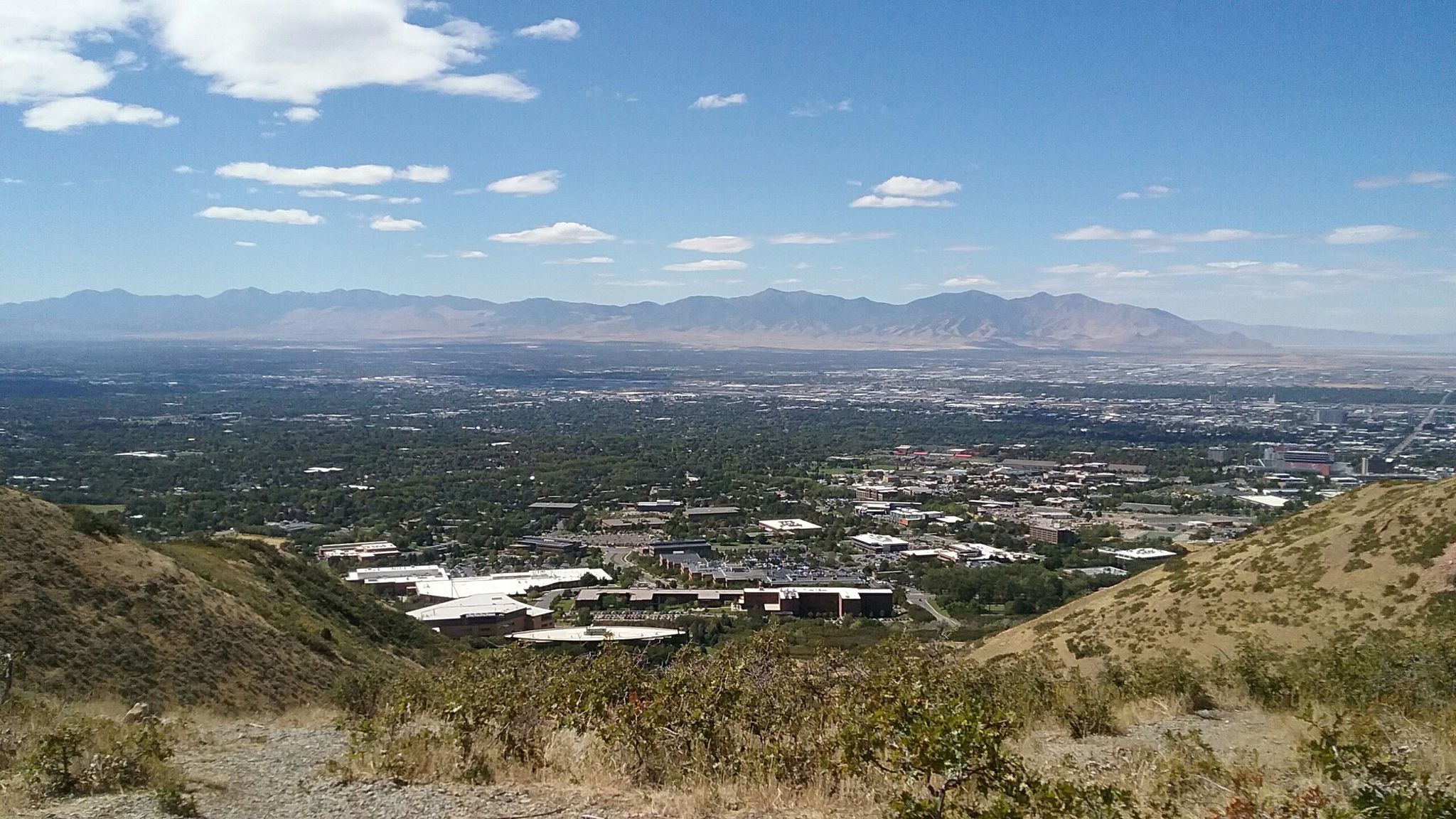 Panoramic view of a city in a valley with distant mountains under a cloudy sky. - Mount Wire and Living Room Loop