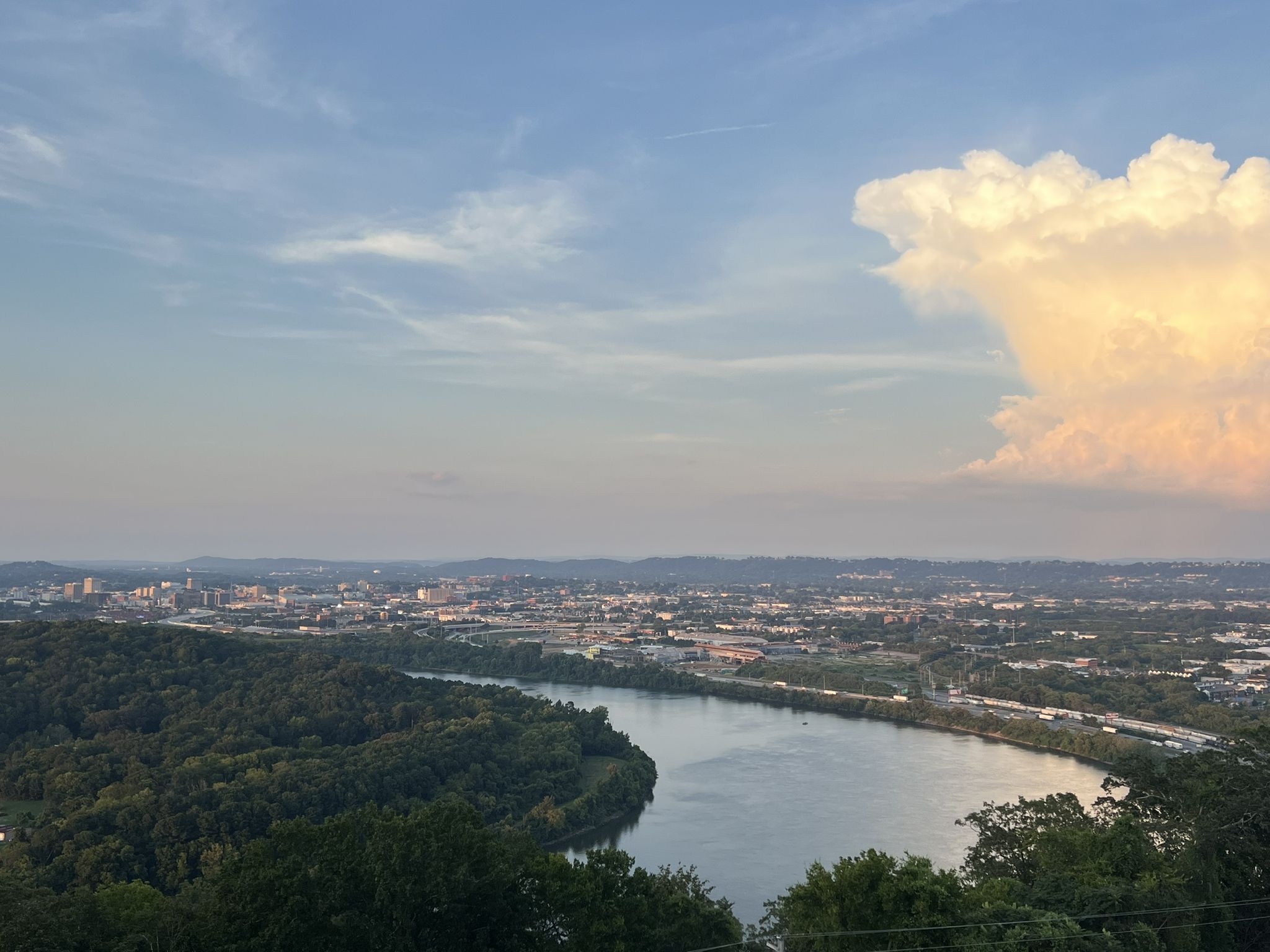 An expansive view of a city and river under a cloudy evening sky. - Incline Rail crossing – Ruby Falls Entrance and Tower loop from Lookout Mountain