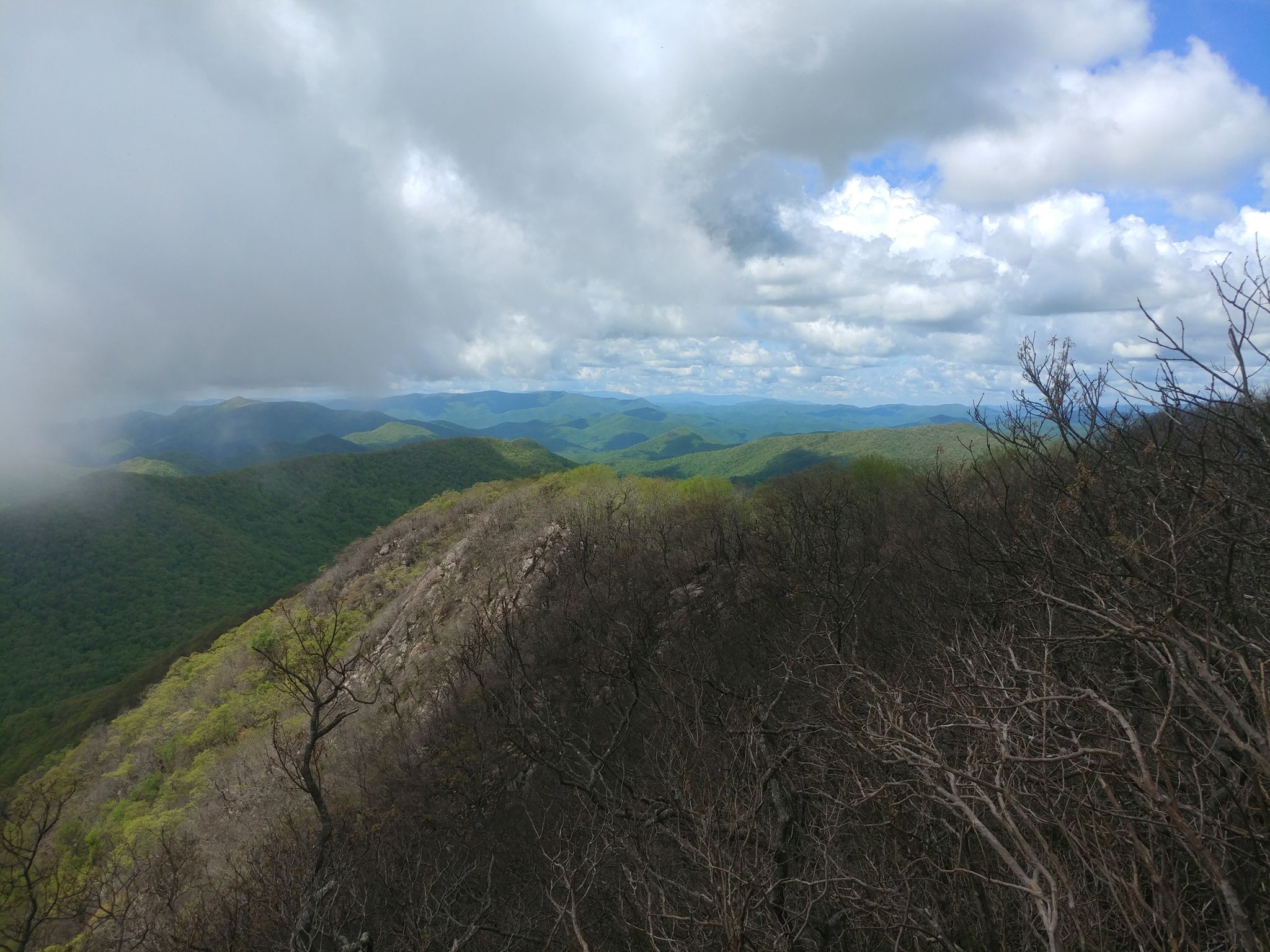 Cloudy sky over a rugged mountain ridge and distant green peaks. - Standing Indian Mountain via Deep Gap