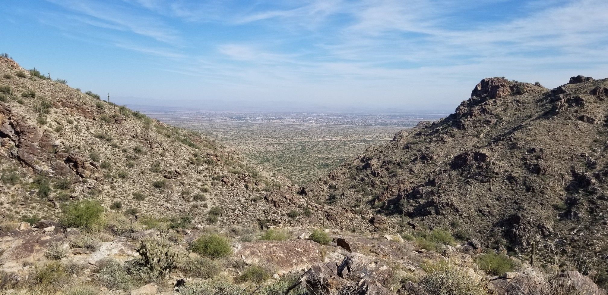 Wide desert valley between two rocky hills under a bright blue sky. - Mesquite and Ford Canyon Loop