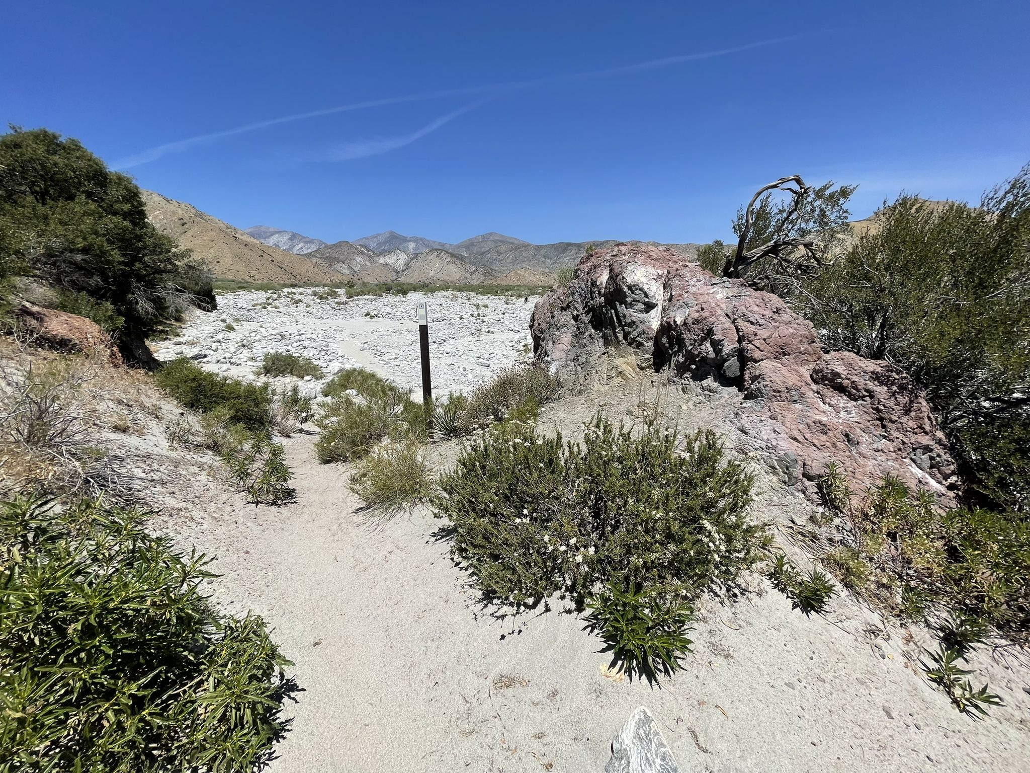 A dry riverbed with mountains in the distance under a clear blue sky. - Whitewater River & Red Dome via PCT – San Bernardino National Forest