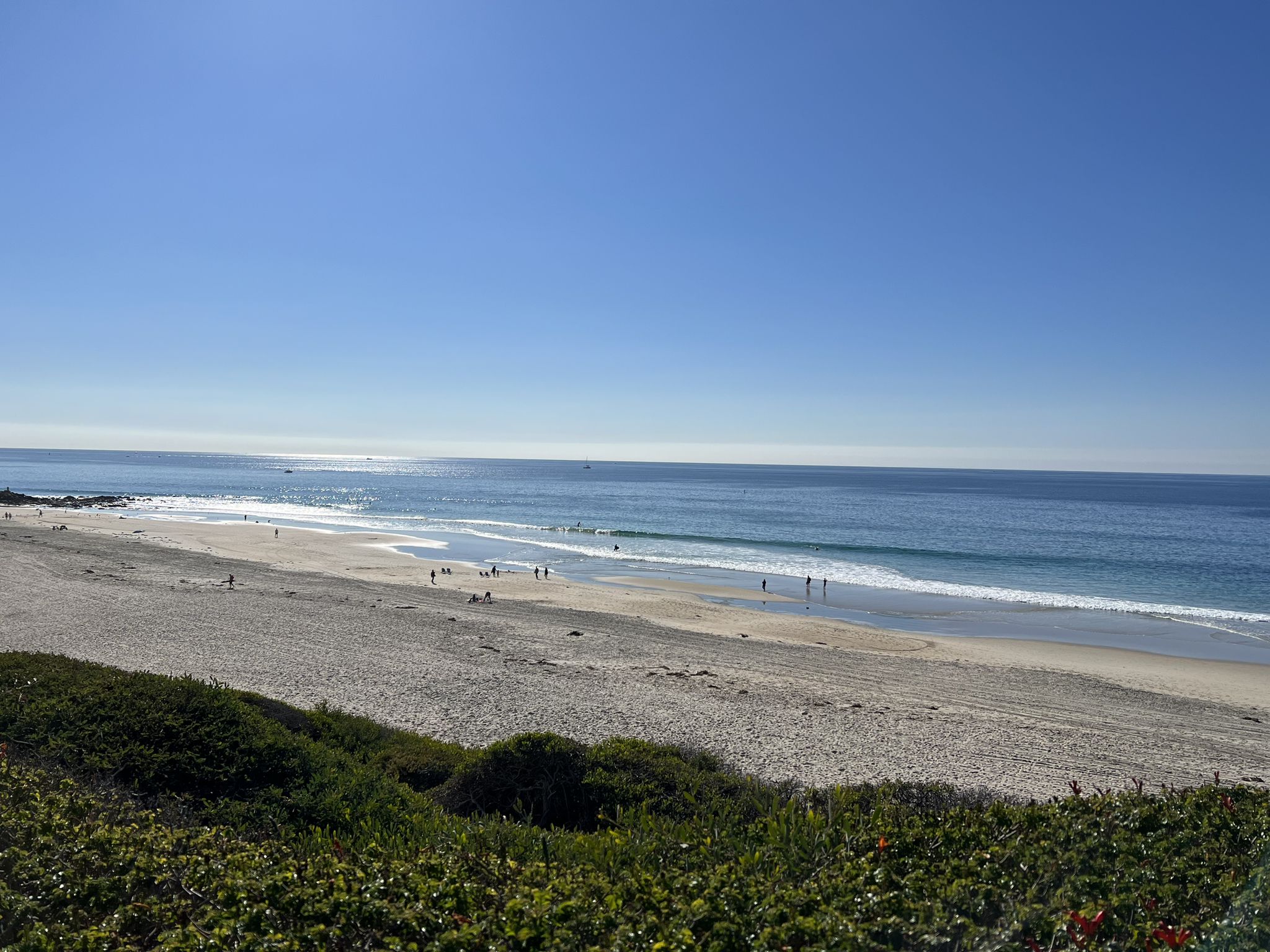 Sunny beach with many people, gentle waves, and clear blue sky. - Salt Creek Beach loop from Dana Point State Marine Conservation Area