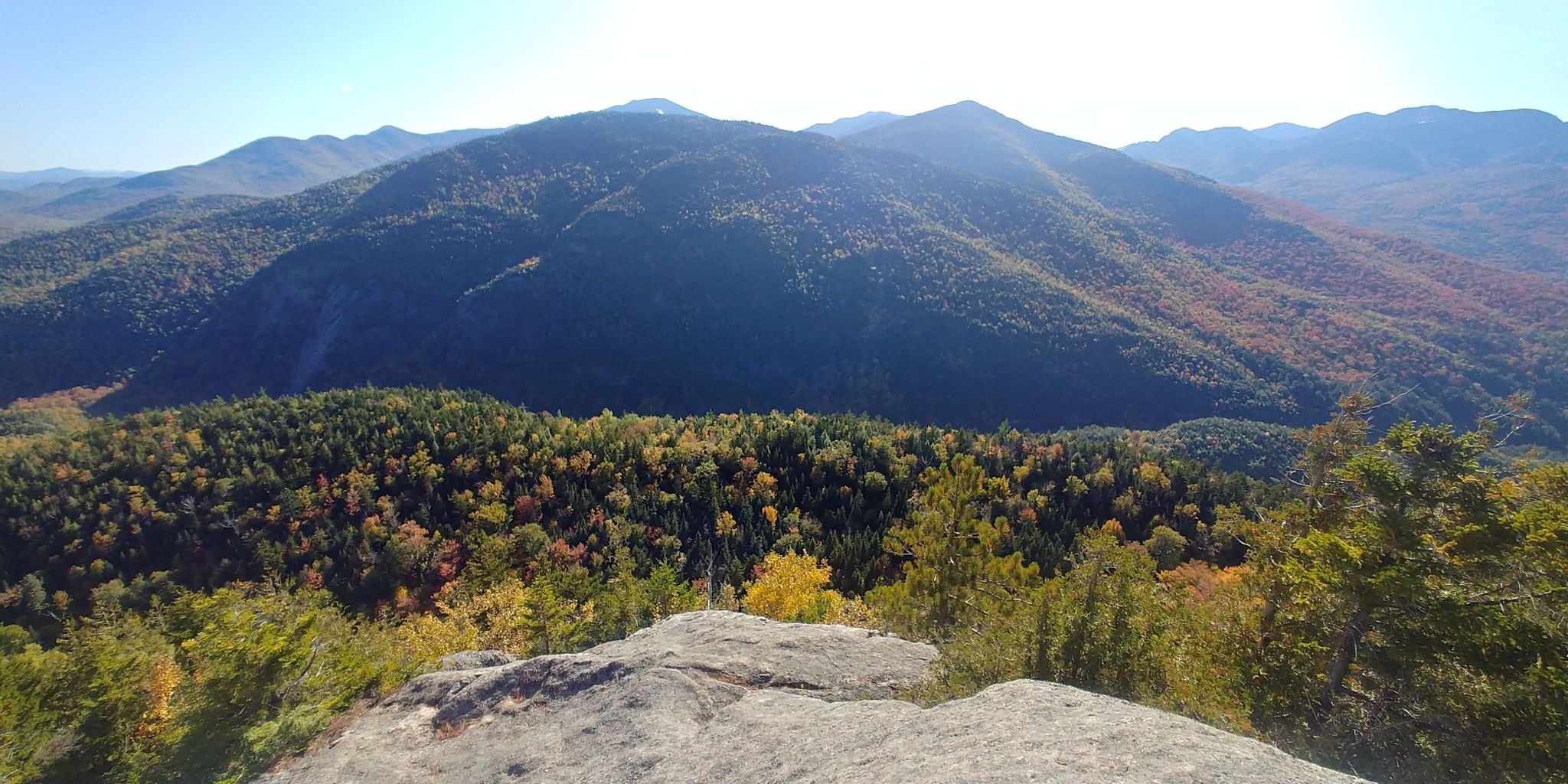 Panoramic view of forested mountains with autumn colors under a clear sky. - Nubble and Giant Washbowl Loop